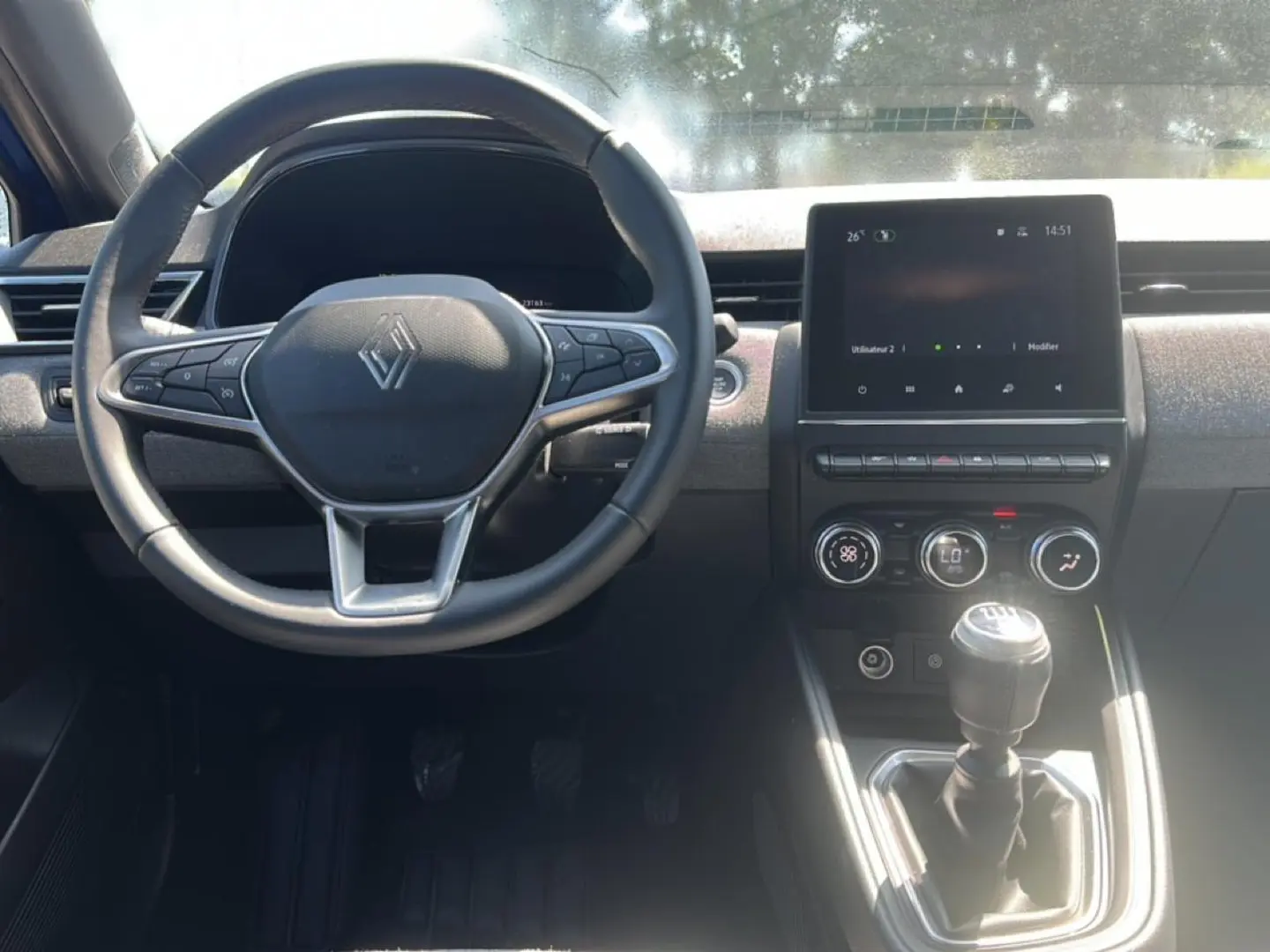 Vue de face de l'intérieur de la Renault Clio V 1.0 TCe 90 Techno avec volant multifonction et écran tactile central.