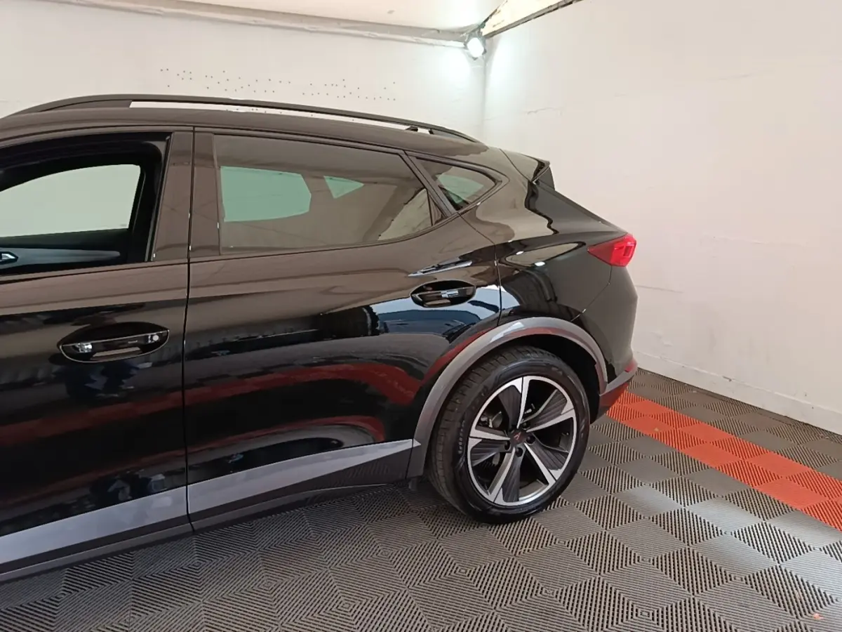Vue latérale droite du CUPRA Formentor noir 2024, mettant en valeur la roue arrière et la ligne de caisse dynamique.