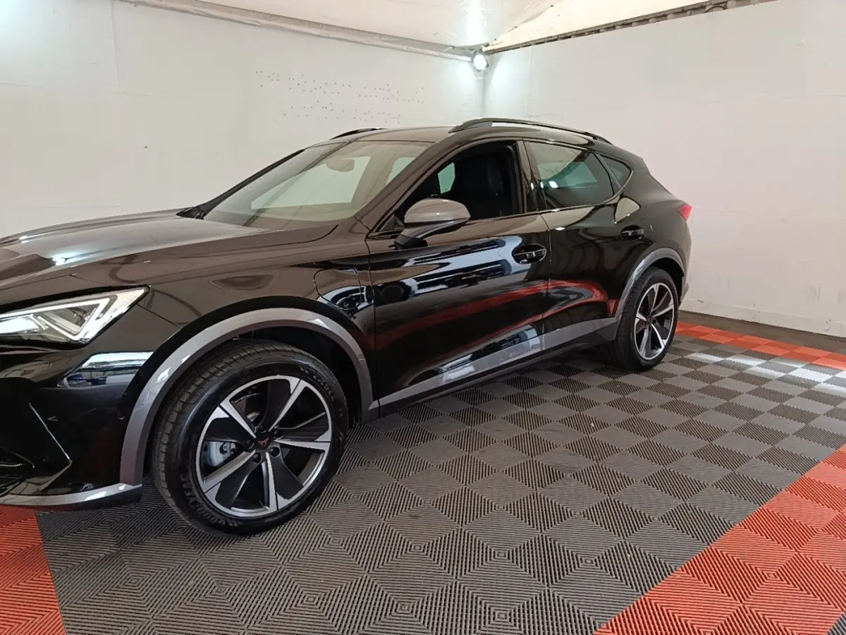 Vue 3/4 avant droit d'un CUPRA Formentor noir 2024 avec jantes alliage et poignées de porte intégrées.