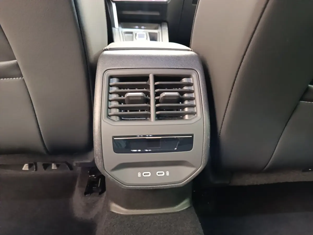 Vue rapprochée des aérateurs arrière et ports USB du siège central d’un CUPRA Formentor noir 2024.