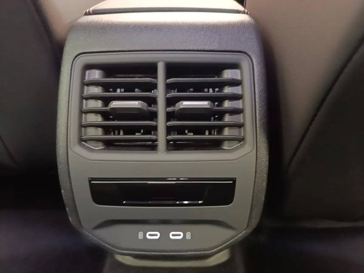 Gros plan sur la console centrale arrière noire du CUPRA Formentor 1.4 e-HYBRID avec bouches d’aération et ports USB.
