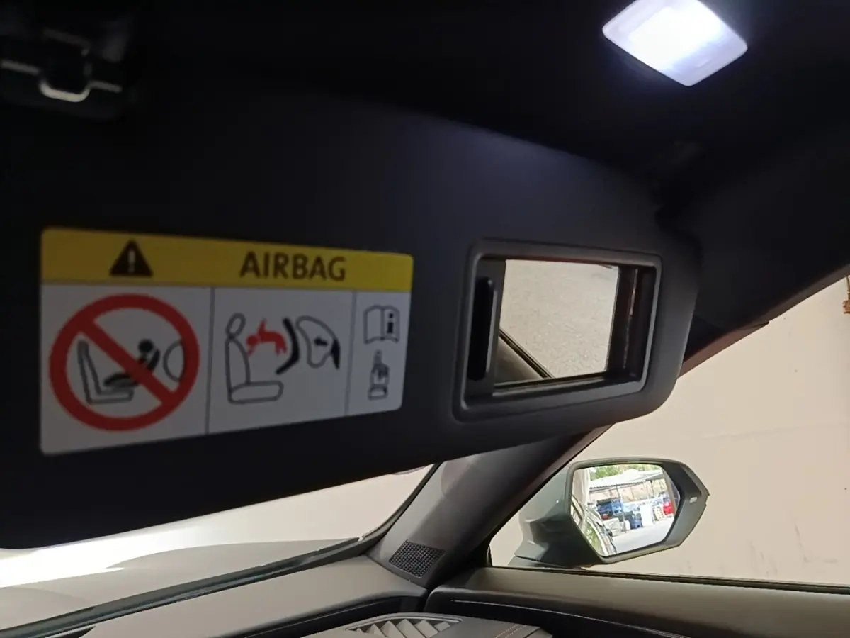 Intérieur du CUPRA Formentor noir 2024, vue côté gauche sur pare-soleil avec miroir et rétroviseur extérieur.