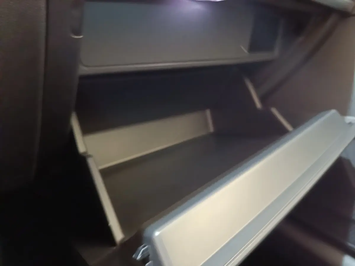 Gant de rangement ouvert côté passager dans l’habitacle du CUPRA Formentor 2024 noir, intérieur sombre.