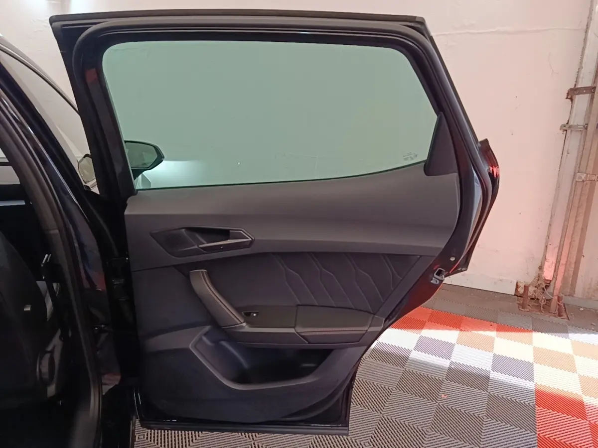 Vue intérieure de la porte arrière gauche noire du CUPRA Formentor 2024, avec garniture en tissu et cuir.