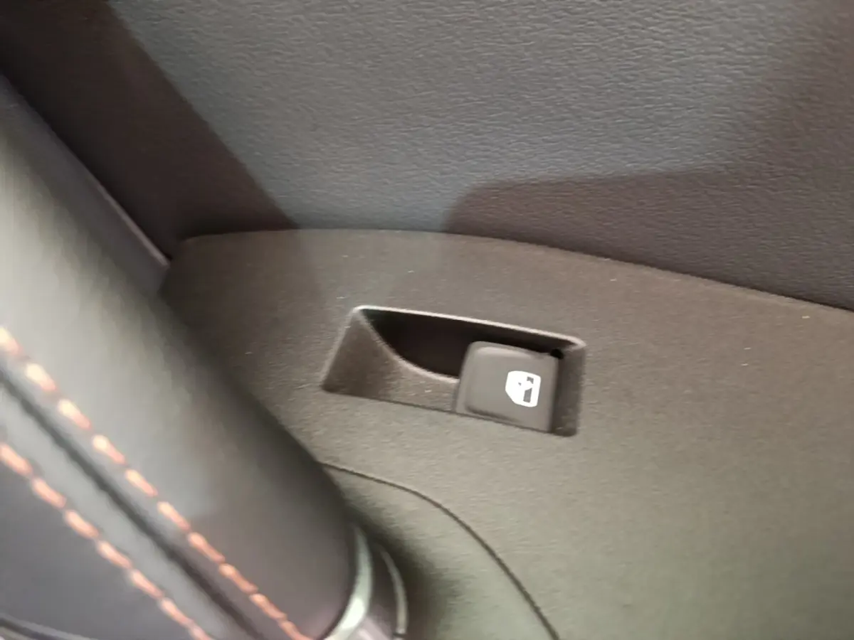 Gros plan sur le bouton d'ouverture de trappe à carburant dans l'habitacle noir du CUPRA Formentor 2024.