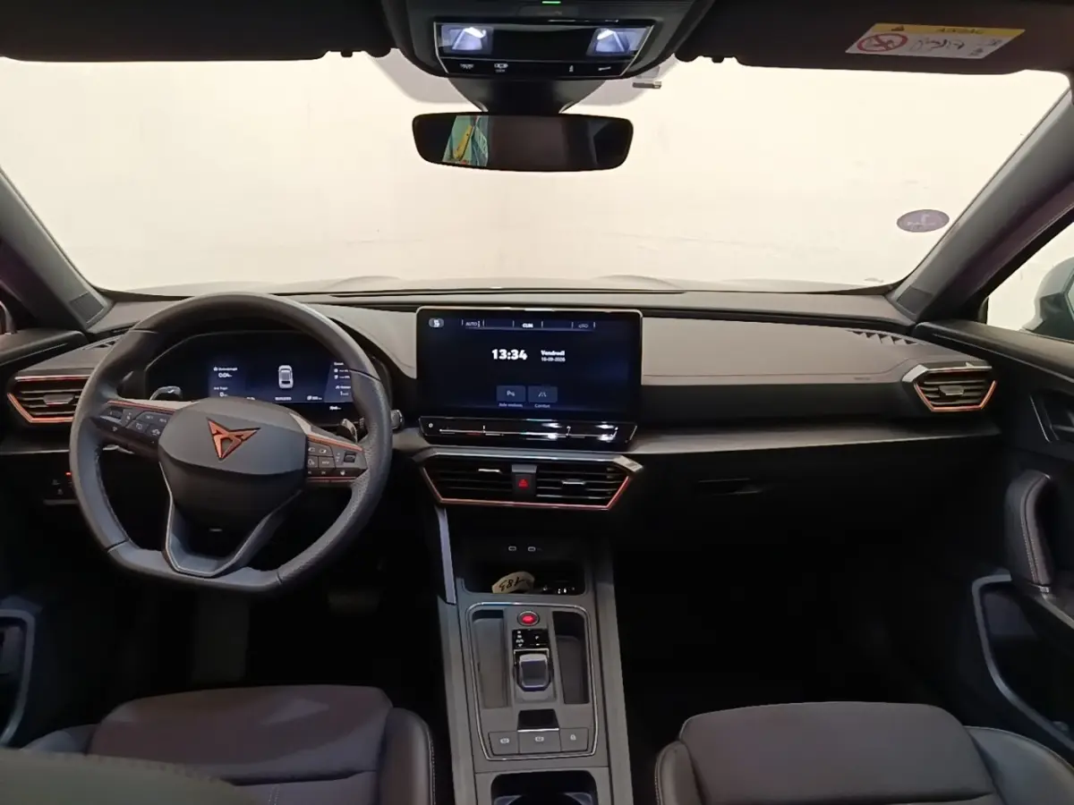 Vue intérieure frontale du tableau de bord noir du CUPRA Formentor 1.4 e-HYBRID avec écran tactile central et volant multifonctions.