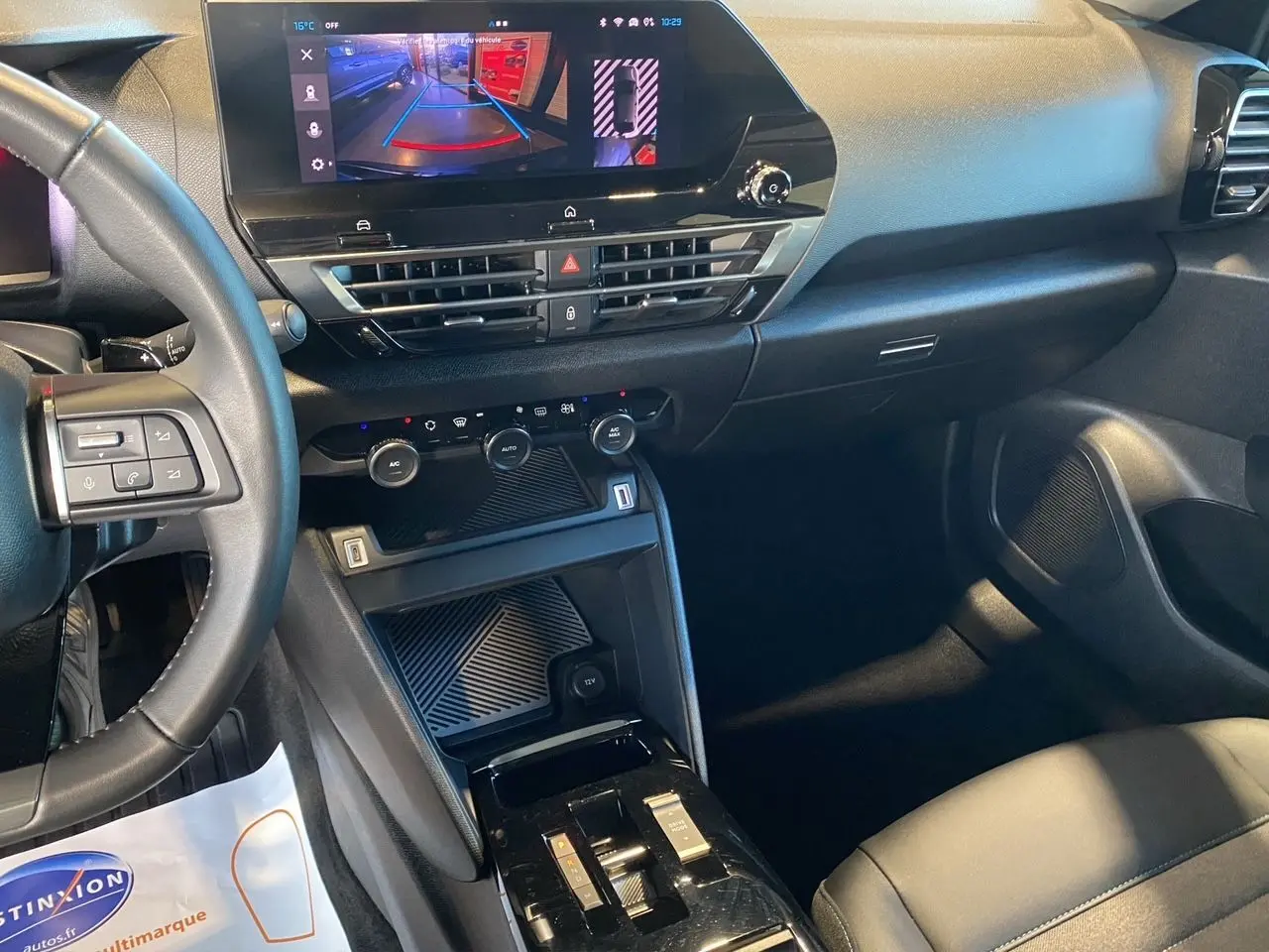 Intérieur noir de la Citroën C4 2023, vue du tableau de bord et console centrale avec écran tactile affichant la caméra de recul.