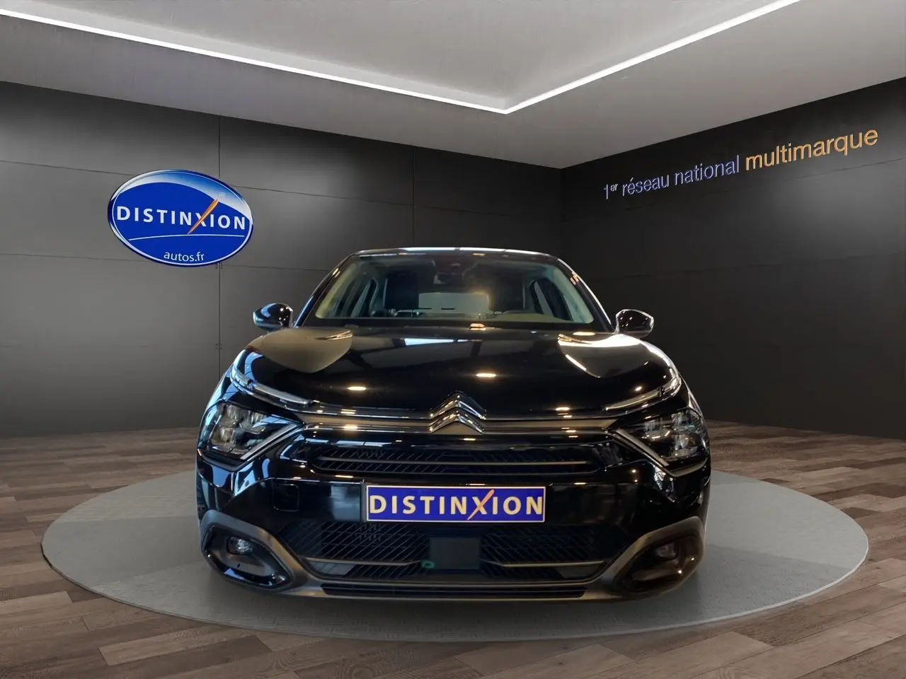 Citroën C4 BlueHDi 130 Plus EAT8 noir Perla Nera vue de face dans un showroom avec logo Distinxion.
