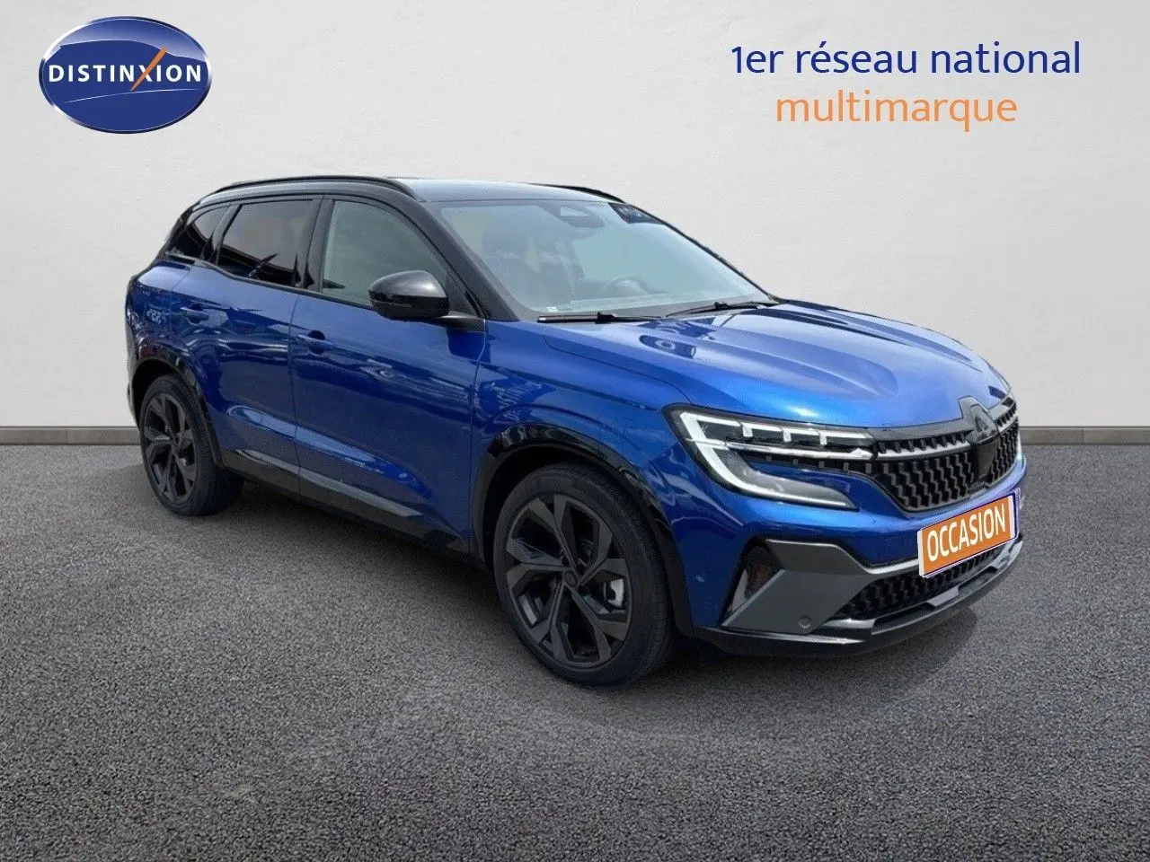 Renault Austral 2024 bleu Iron avec toit noir, vue 3/4 avant droit mettant en valeur ses optiques LED et jantes noires.