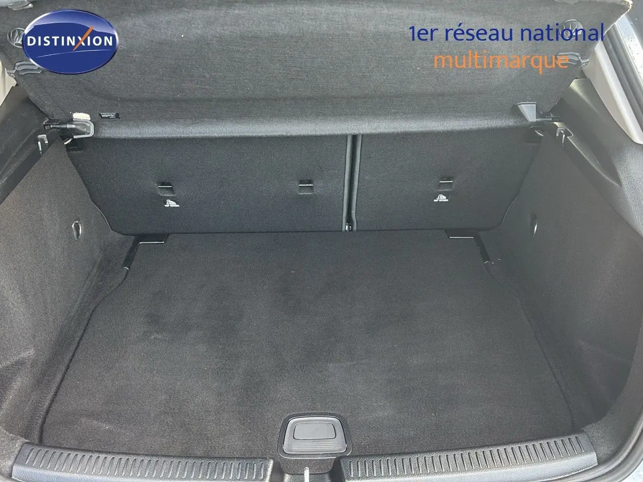 Coffre ouvert d'une Mercedes Classe A 200D gris montagne métal, vue intérieure arrière montrant l'espace de chargement vide.