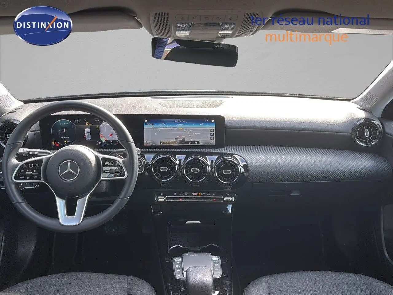 Vue intérieure avant du tableau de bord et volant noir d'une Mercedes Classe A 200D 2021 avec écran tactile et aérateurs ronds.
