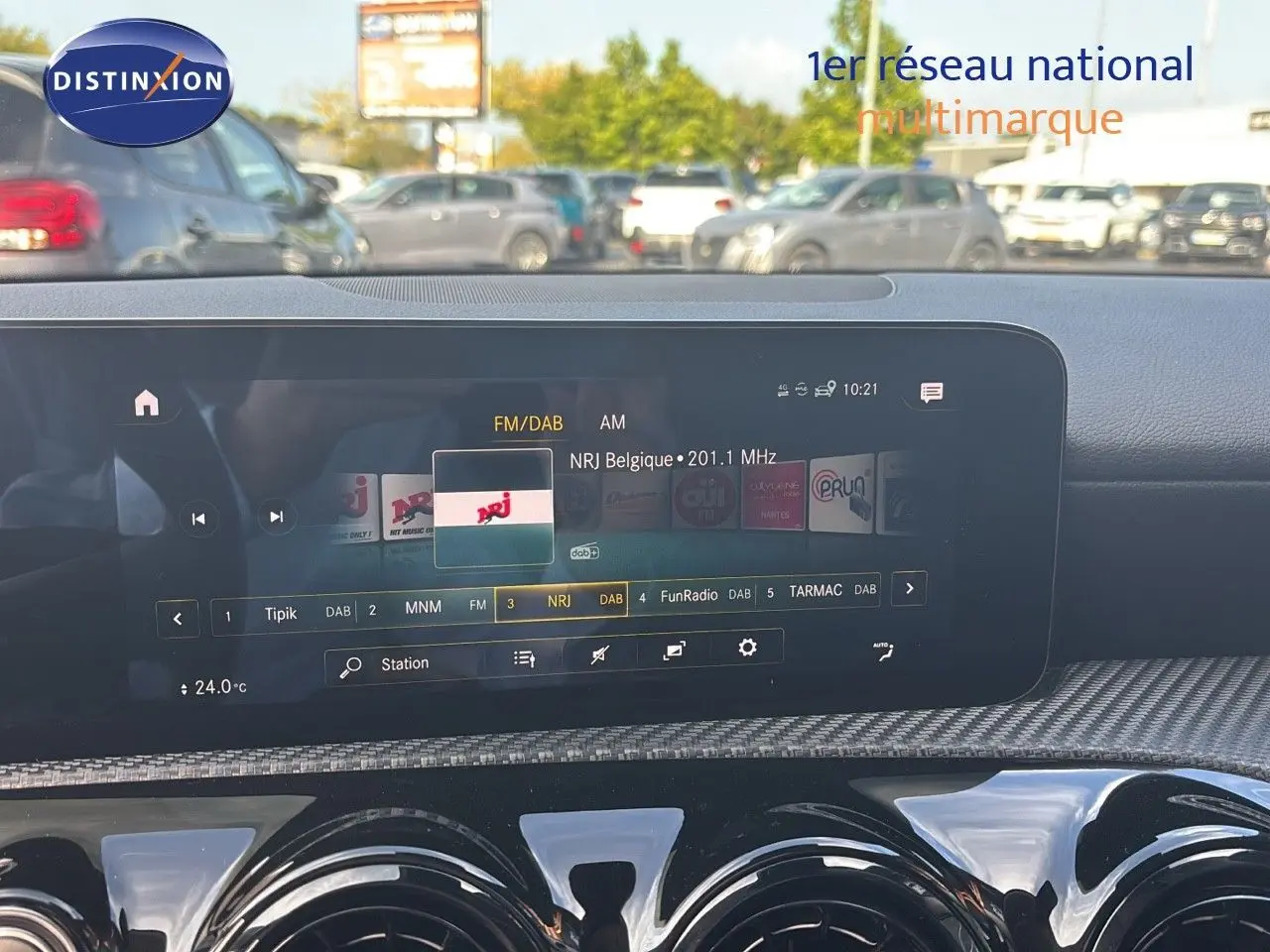 Écran tactile central affichant la radio NRJ dans l'habitacle moderne d'une Mercedes Classe A gris montagne métal.