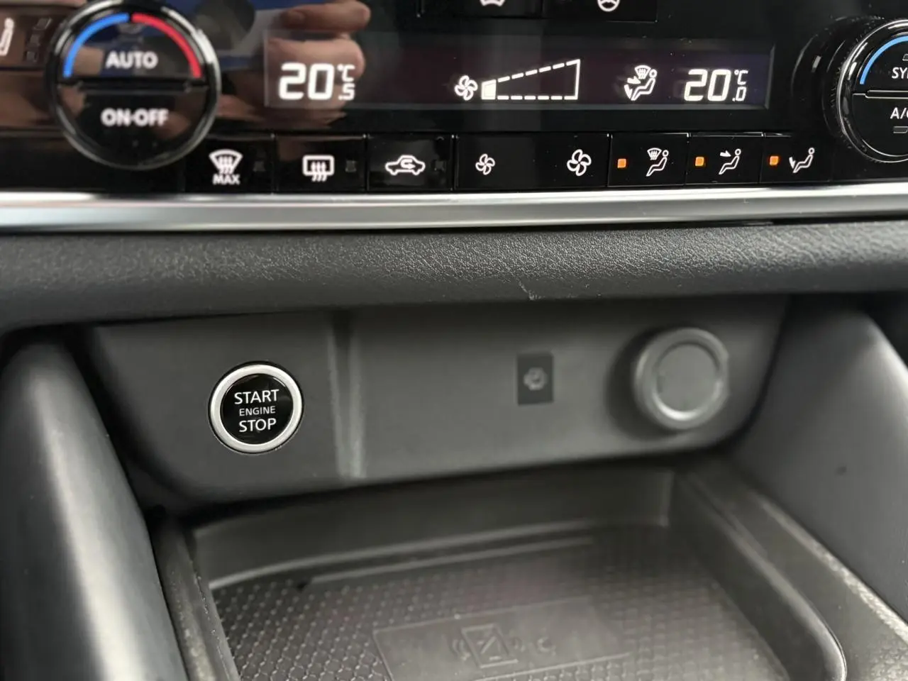 Gros plan sur la console centrale du Nissan Qashqai 2024 montrant le bouton Start/Stop et commandes de climatisation.