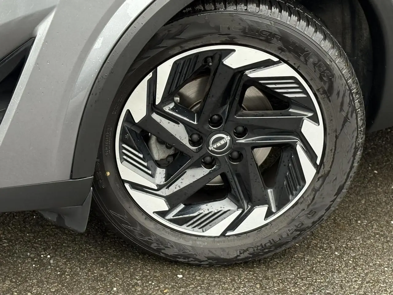 Gros plan sur la jante alliage 18 pouces bicolore noir et argent du Nissan Qashqai gris Squale, côté avant droit.