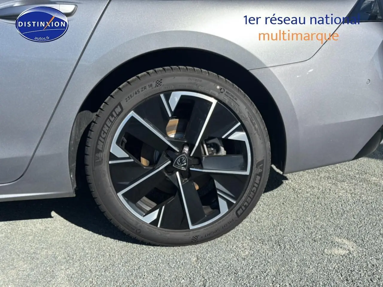 Gros plan sur la roue arrière droite de la Peugeot 508 SW Hybrid 225 GT e-EAT8 gris Artense avec jante alu noire et argent.