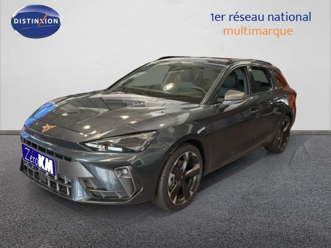 Vue 3/4 avant droite d'une CUPRA Leon ST gris métallisé avec jantes aluminium et barres de toit visibles.