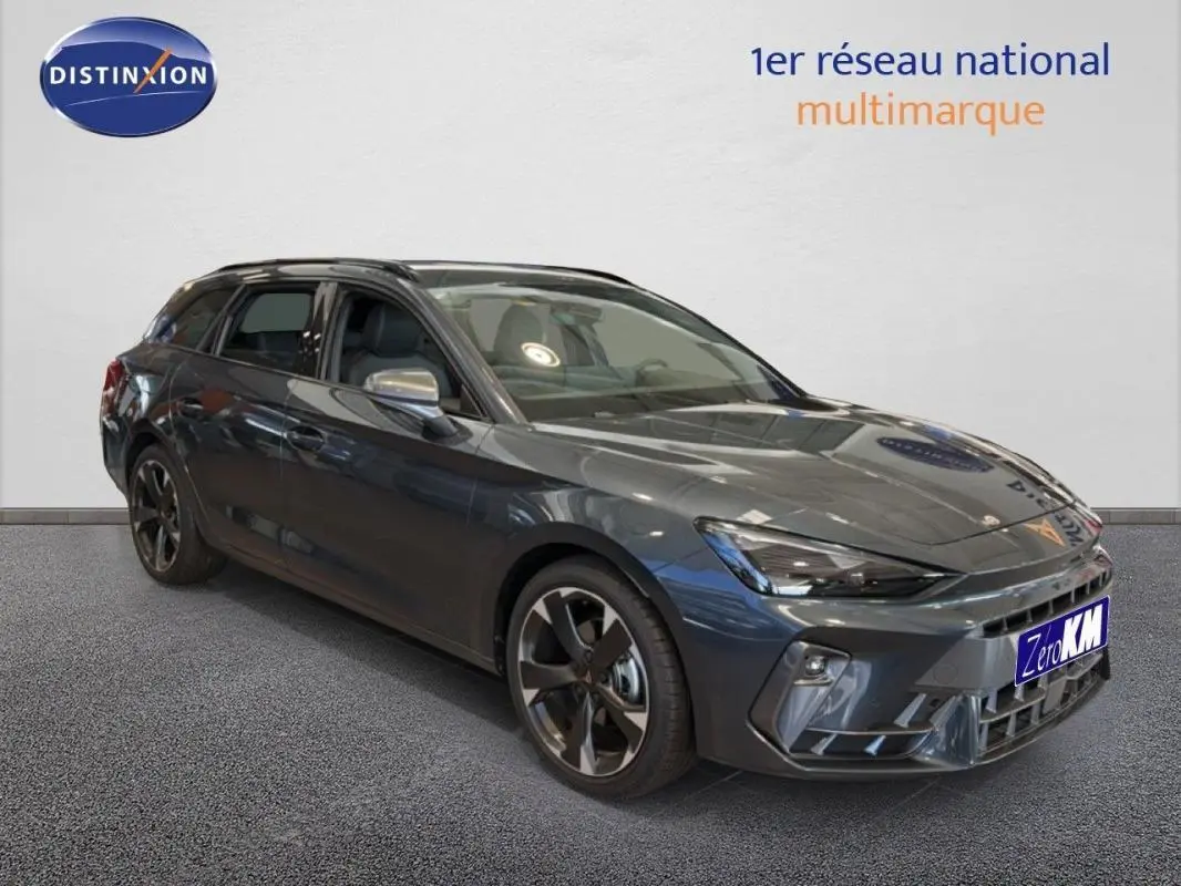 Vue 3/4 avant d'une CUPRA Leon ST gris métallisé avec barres de toit et jantes aluminium distinctives.