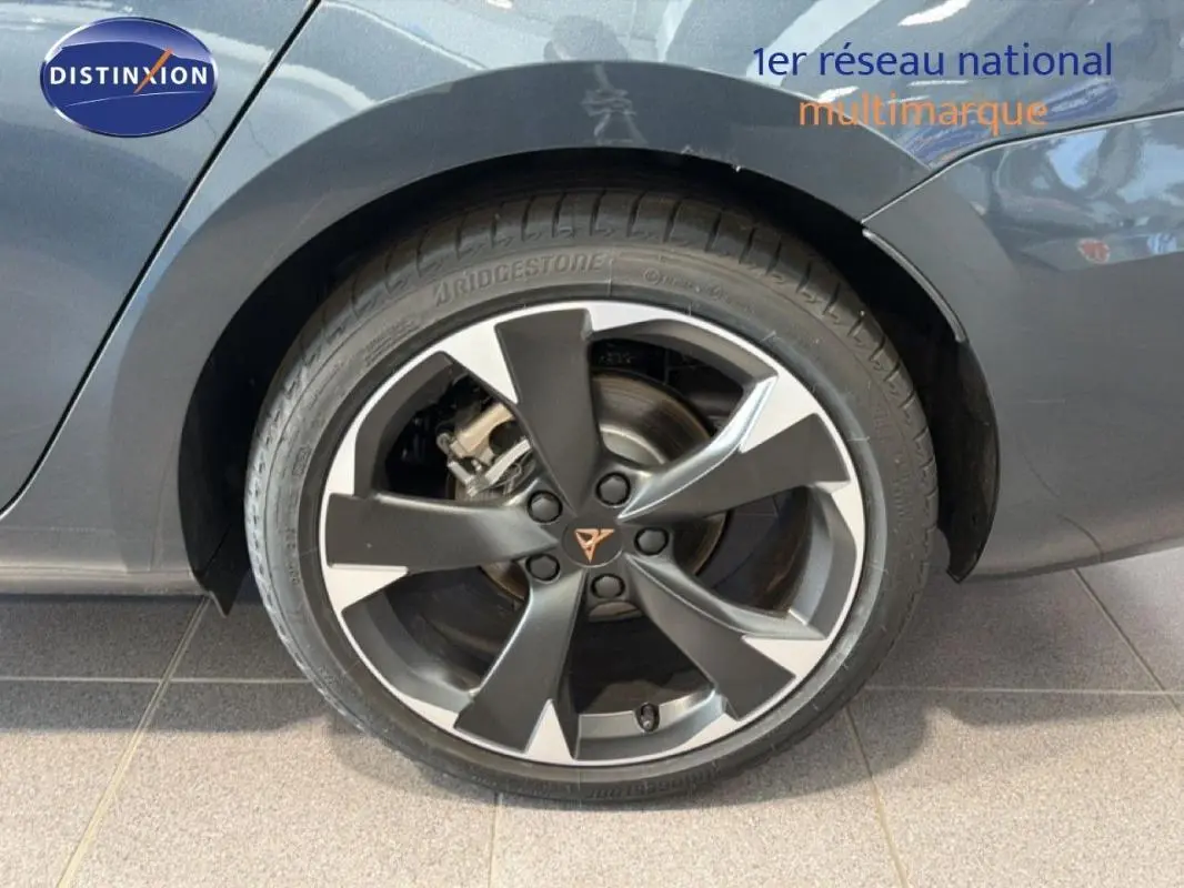 Gros plan sur la roue arrière droite d'une CUPRA Leon gris 2025 avec jante aluminium bicolore et logo CUPRA central.