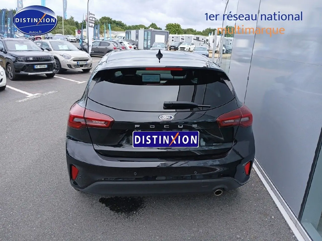 Vue arrière d'une Ford Focus 2024 noir Agate métallisé, avec feux arrière LED et sortie d'échappement chromée visible.