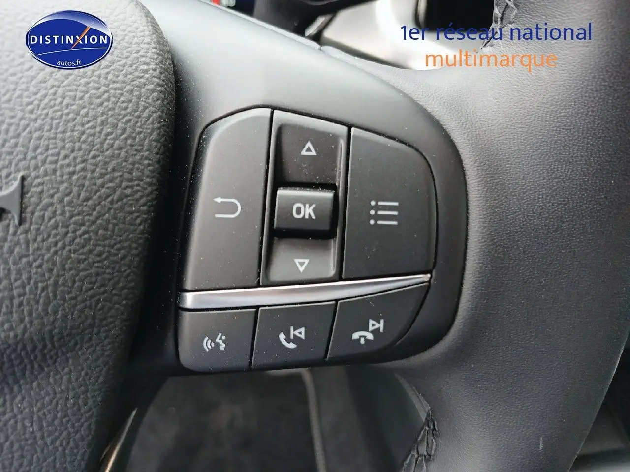 Gros plan sur les commandes multifonctions du volant cuir noir de la Ford Focus 2024 finition Titanium X Business.