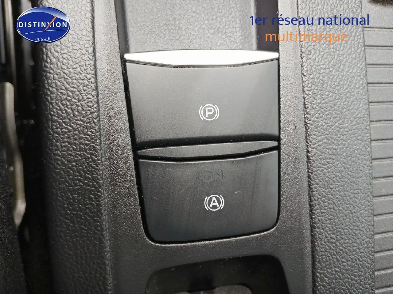 Gros plan sur les commandes de frein à main électrique et arrêt automatique dans l'habitacle d'une Ford Focus noir Agate 2024.