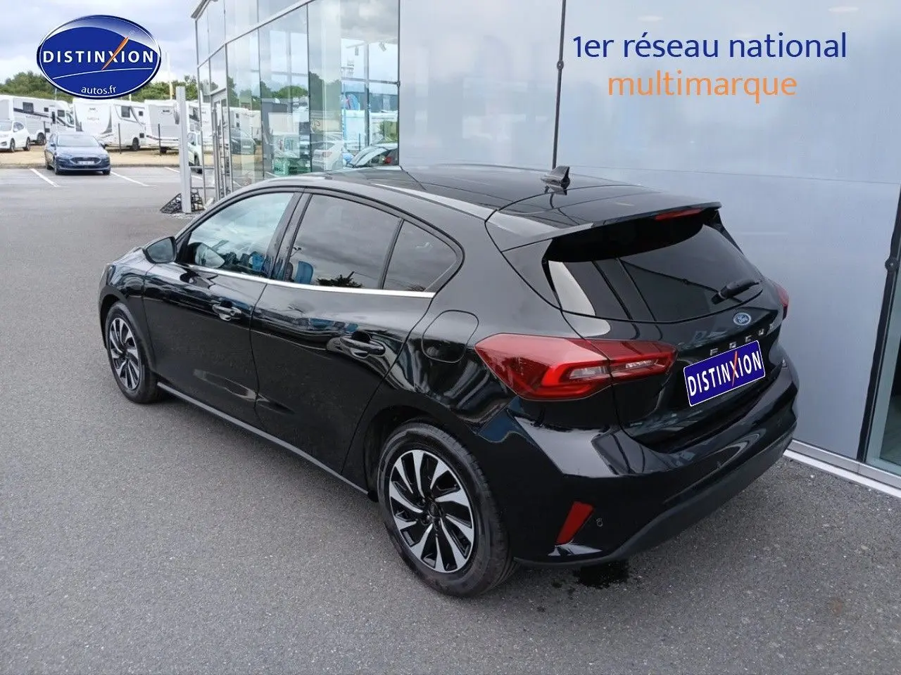 Ford Focus 2024 noir Agate métallisé vue 3/4 arrière côté gauche, avec vitres surteintées et jantes bicolores.