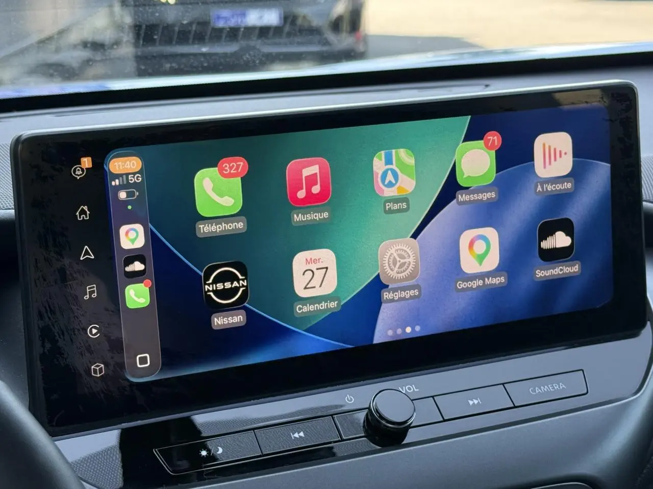 Écran tactile central du Nissan Juke 2025 montrant l'interface Apple CarPlay avec plusieurs applications visibles.