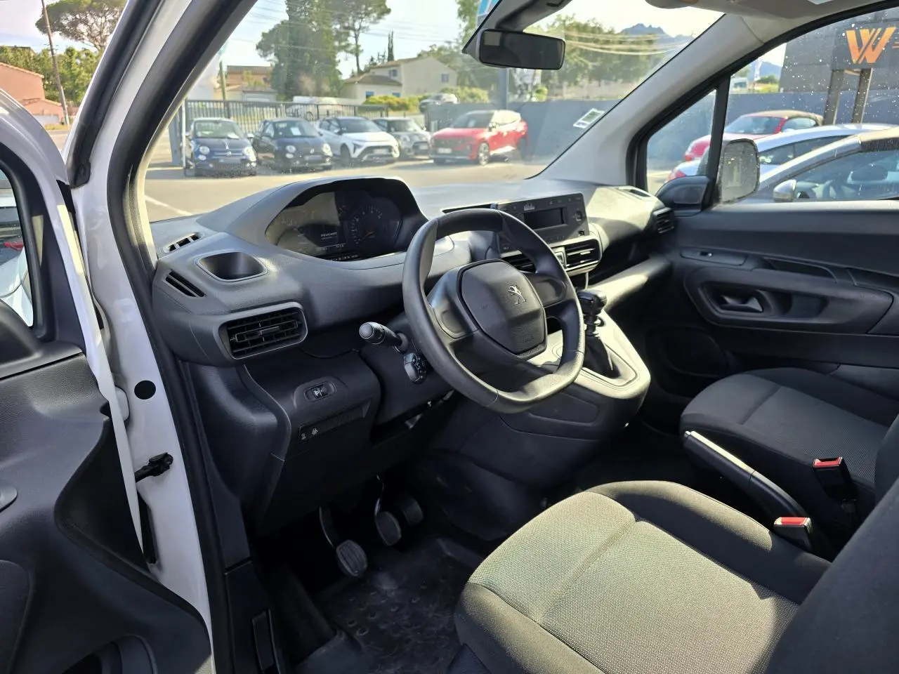 Intérieur du Peugeot Rifter blanc, vue côté conducteur, volant compact et tableau de bord avec écran central.