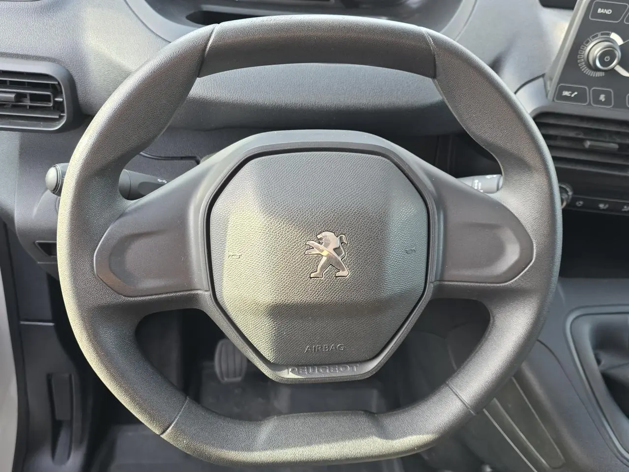 Vue rapprochée du volant noir Peugeot au design compact dans l'habitacle du Rifter 1.5 BlueHDi 2021.
