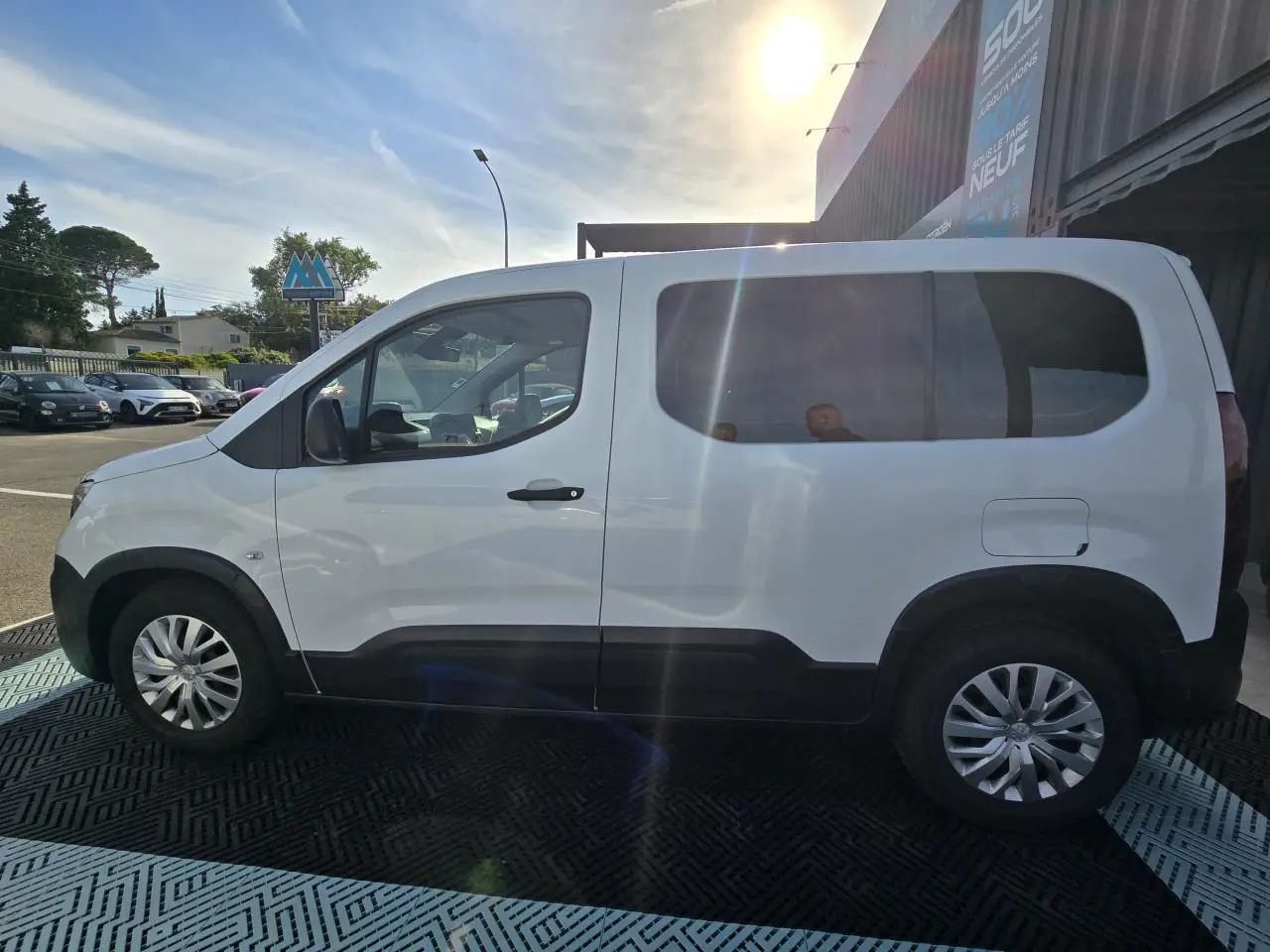 Peugeot Rifter blanc banquise vu de profil côté gauche, avec vitres arrière teintées et jantes tôle argentées.