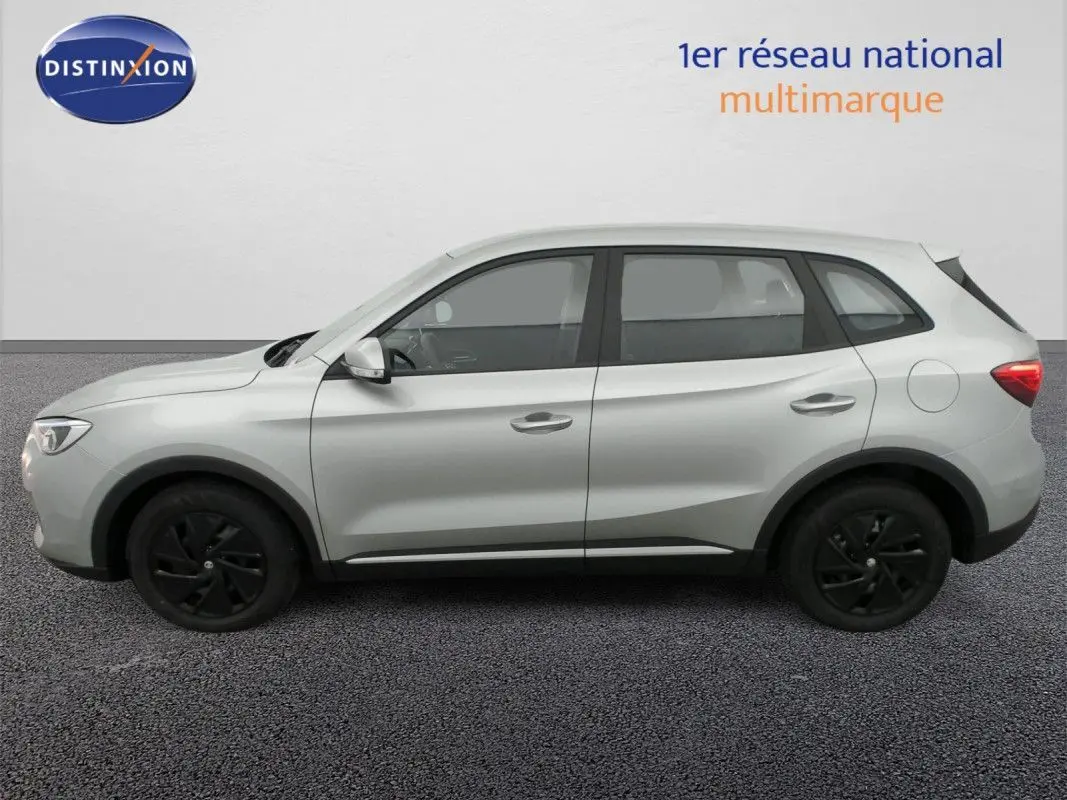 Vue de profil côté gauche du MG ZS 1.5 L HYBRID+ 197CH 2026 en Cosmic Silver avec jantes noires.