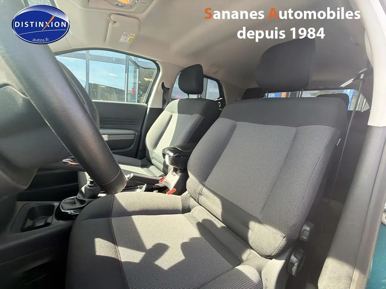 Vue intérieure côté conducteur du Citroën C4 Cactus 2020, sièges tissu gris et volant en croûte de cuir.