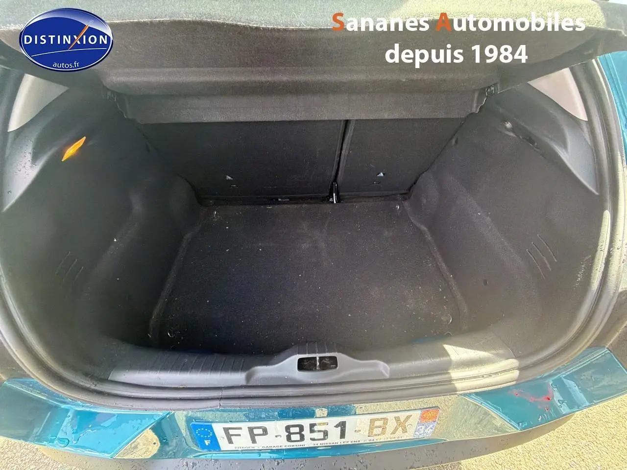 Coffre ouvert vu de dessus d’une Citroën C4 Cactus bleu métal, montrant un espace de rangement vide et propre.