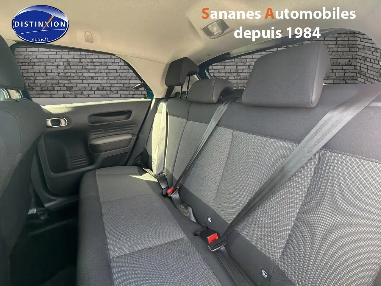 Vue intérieure des sièges arrière en tissu gris de la Citroën C4 Cactus, côté gauche, avec ceintures attachées.