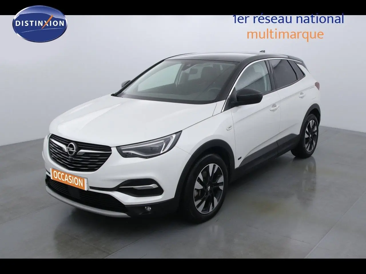 Opel Grandland X blanc nacré vue 3/4 avant droit avec toit noir et jantes alliage bicolores.