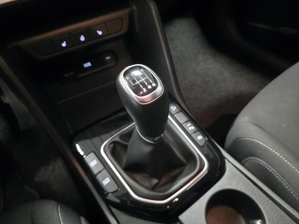 Le levier de vitesses manuel noir du Kia Sportage 2022, vu en gros plan depuis le siège conducteur.