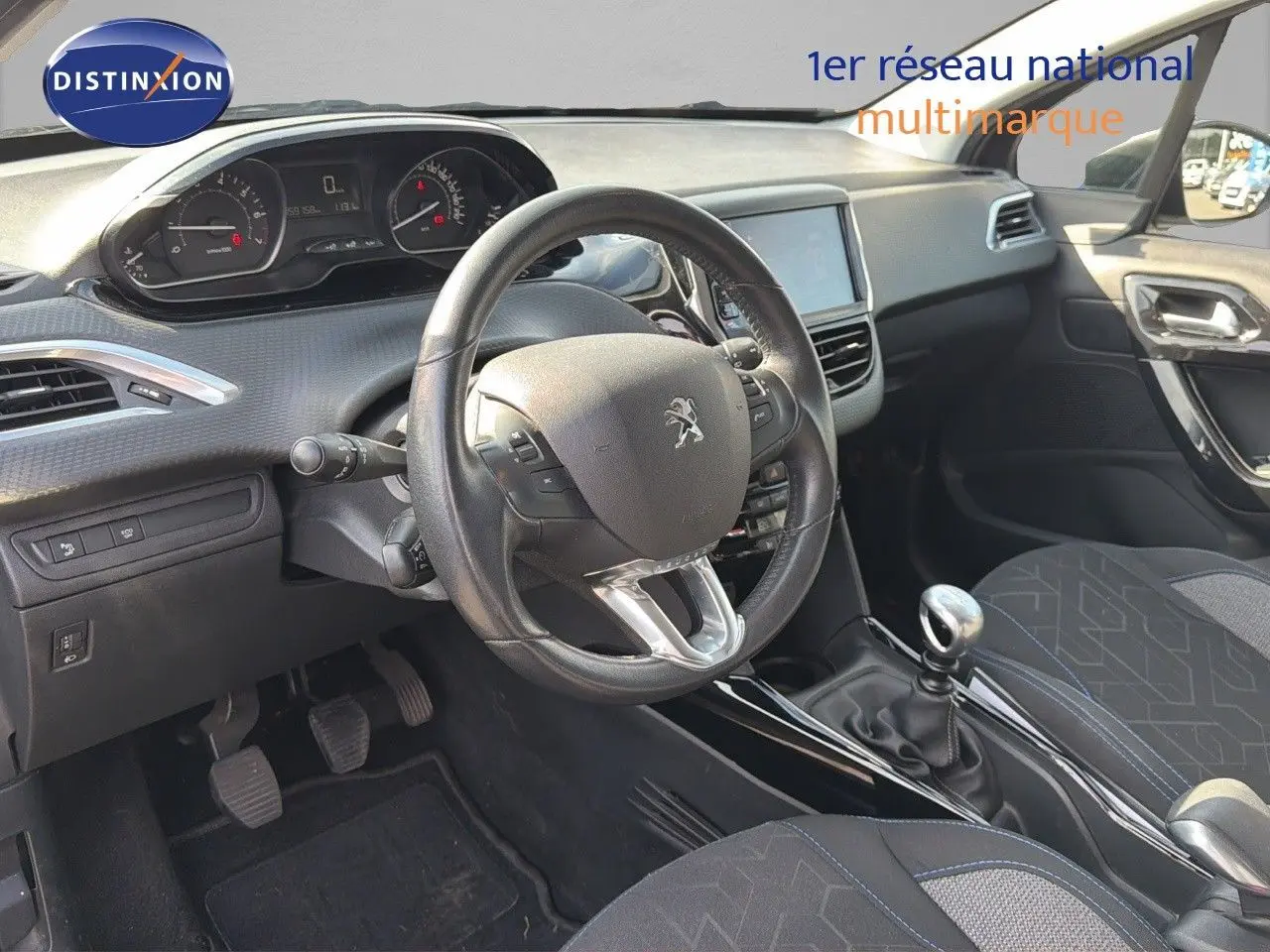 Intérieur de la Peugeot 2008 2019 essence gris platinium, vue du poste de conduite avec volant cuir et levier de vitesse manuel.