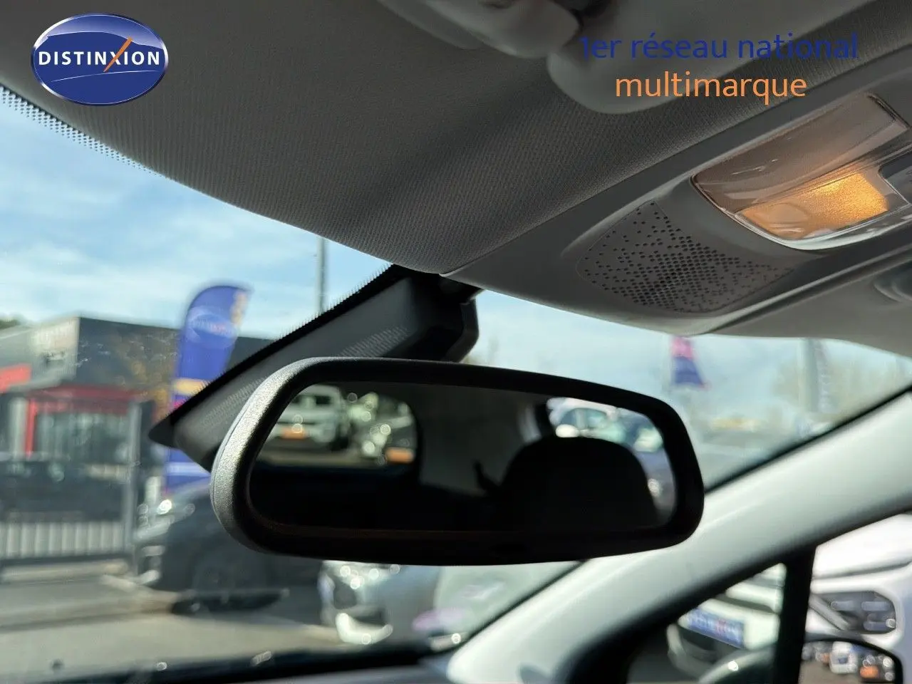 Rétroviseur intérieur montrant l'habitacle d'une Peugeot 2008 gris platinium en stationnement extérieur.