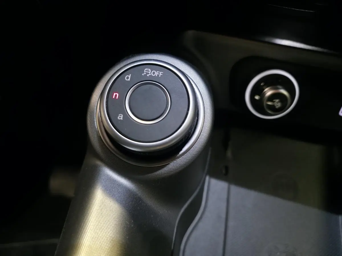 Gros plan sur le sélecteur de mode de conduite Alfa DNA dans l’habitacle de l’Alfa Romeo Tonale gris.