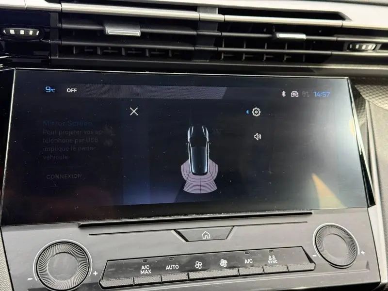 Écran tactile intérieur de la Peugeot 308 2024 montrant l'alerte de proximité arrière, avec commandes climatisation en dessous.