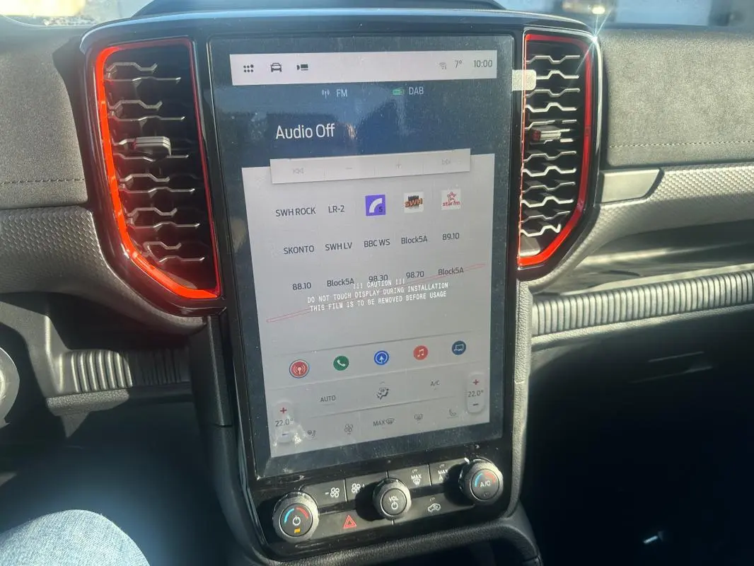 Vue rapprochée de l’écran tactile central du Ford Ranger Raptor 2025 blanc, avec cadre noir et contours rouges.