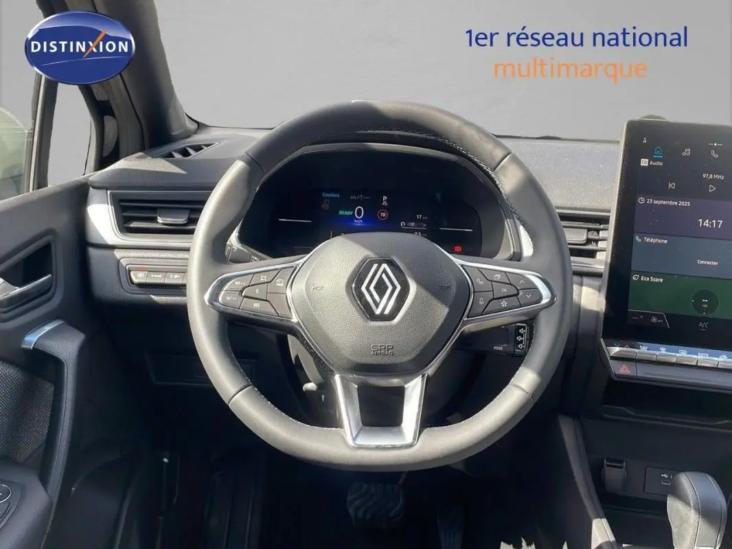Vue intérieure centrée sur le volant cuir et tableau de bord numérique du Renault Captur noir 2025, avec écran tactile visible.