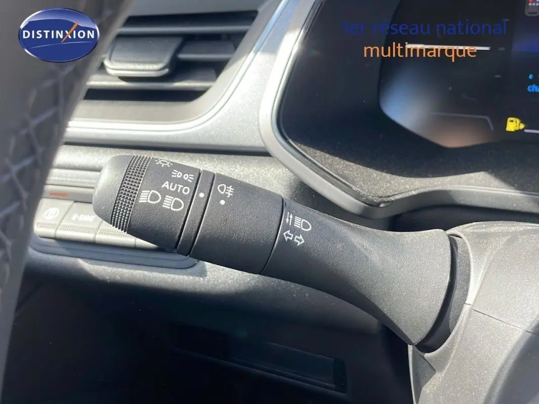 Gros plan sur la commande des feux et clignotants du Renault Captur noir 2025, intérieur moderne et fonctionnel.