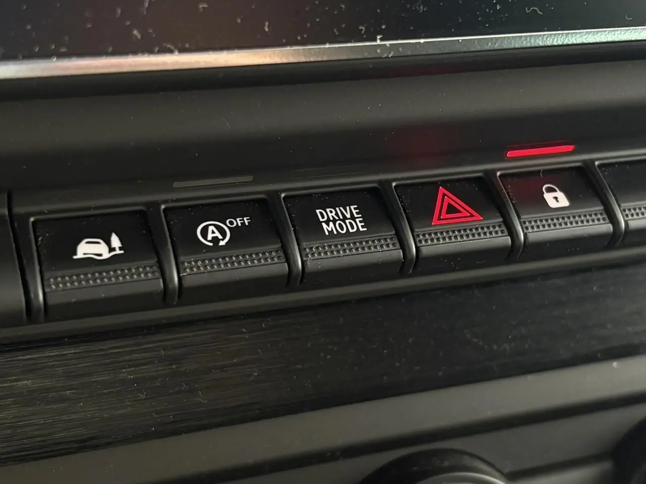 Gros plan sur les boutons de commande noirs du tableau de bord du Nissan Primastar gris Comète, version 2025.