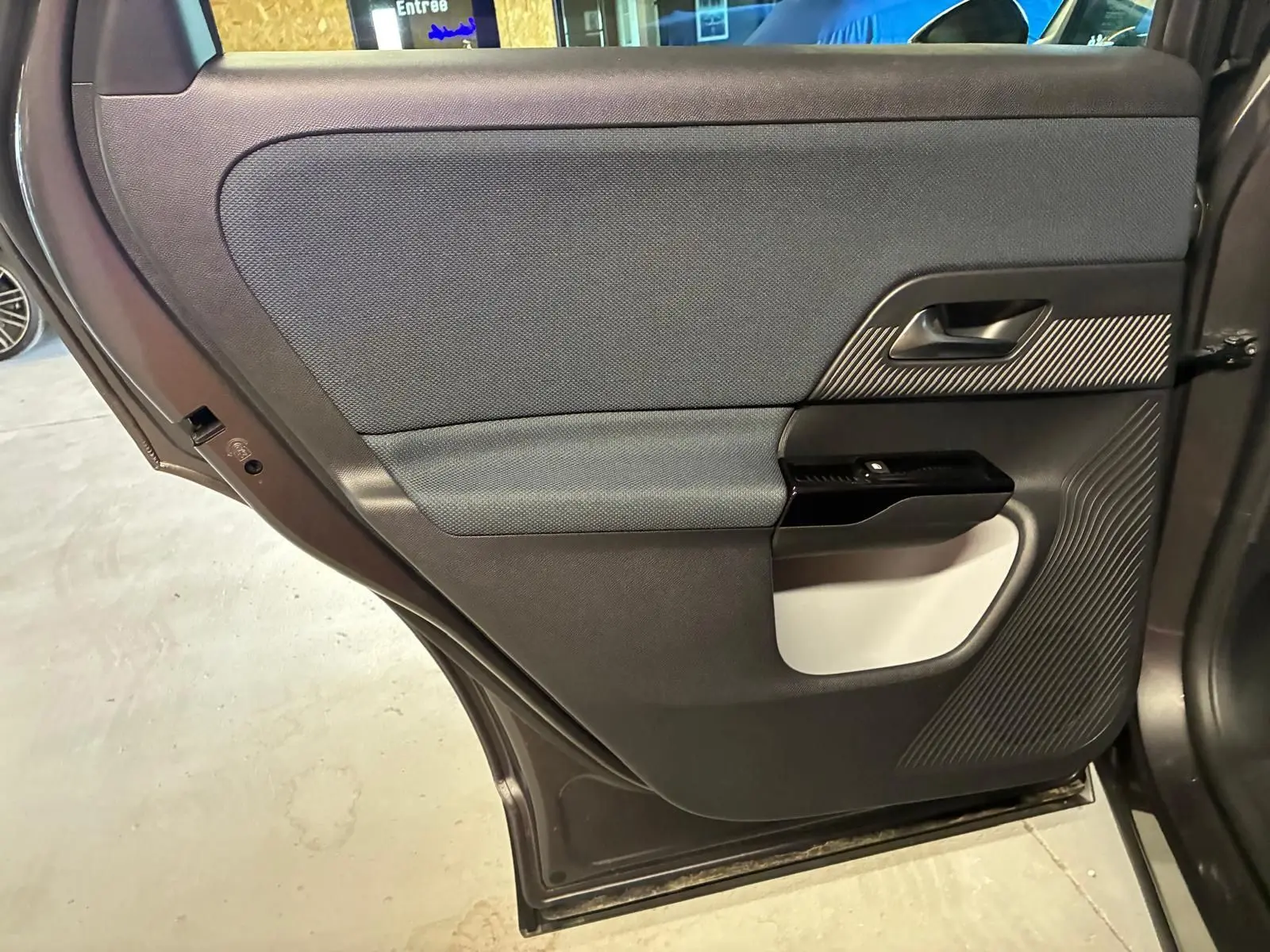 Vue rapprochée de la porte arrière gauche grise du Citroën C5 Aircross 1.2 Hybride 2026, avec insert texturé noir et tissu gris.