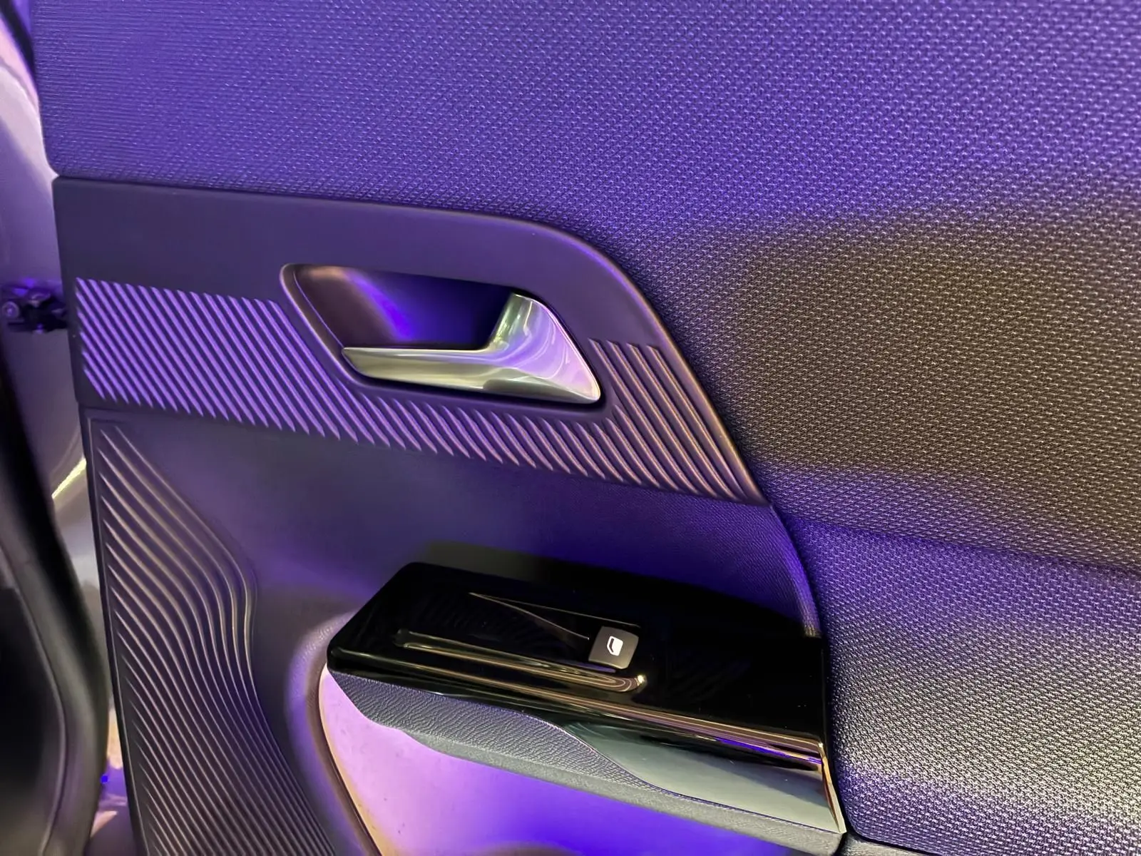 Détail de la porte intérieure côté gauche du Citroën C5 Aircross gris 2026, avec poignée argentée et commande de vitre.