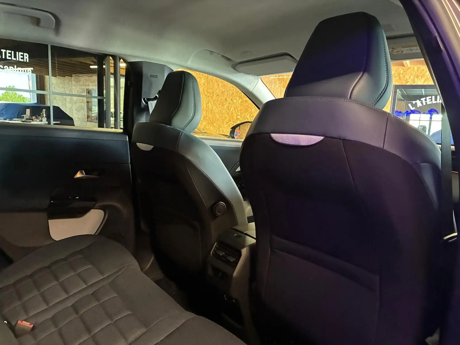 Vue intérieure arrière du Citroën C5 Aircross gris, mettant en valeur les sièges en tissu noir et l'espace aux jambes.