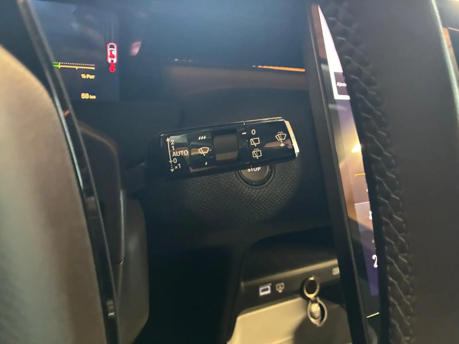 Gros plan sur la commande d’essuie-glace à gauche du volant dans l’habitacle sombre du Citroën C5 Aircross gris.