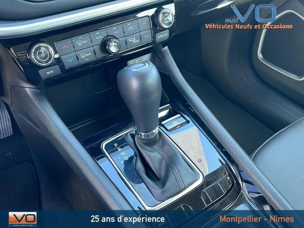 Gros plan sur la console centrale du Jeep Compass 2024 avec levier de boîte auto et commandes climatisation.