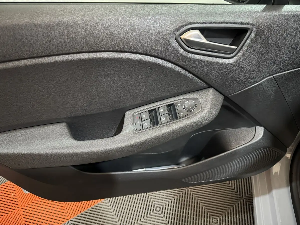 Panneau de porte côté gauche gris clair de Renault Clio 2025 avec commandes électriques des vitres et poignée intégrée.